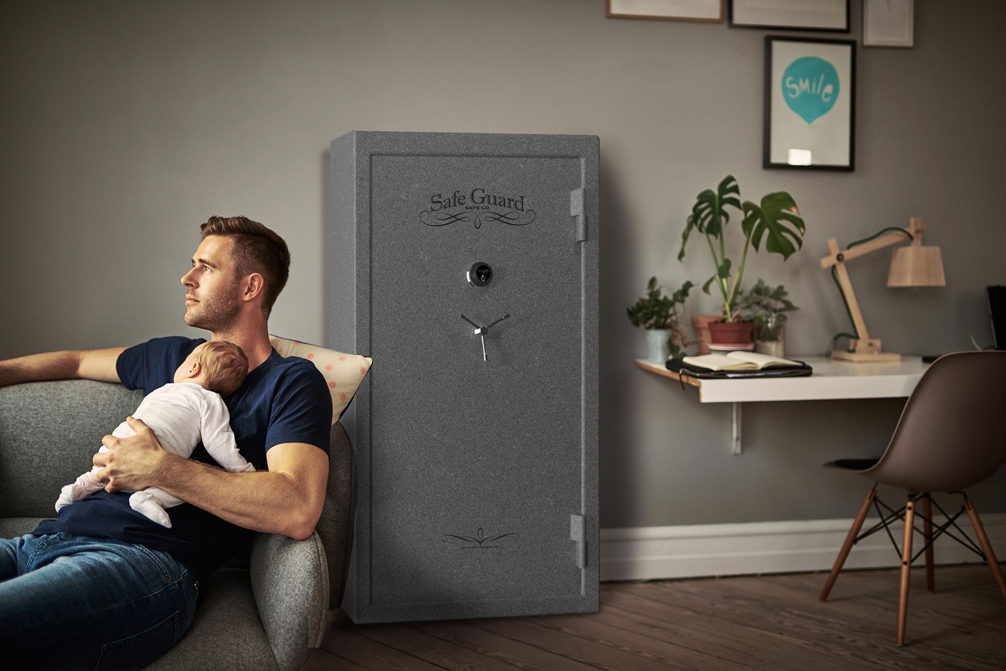 Father holding baby with gun safe installed in living room